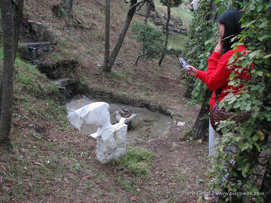 RoccoloAvesaGanda 111.jpg - L'uccello marmoreo è collocato alla base di una serie di cascatelle d'acqua dove l'acqua discendente alimenta una vasca con al centro un vaso di ciclamini di bosco in fiore